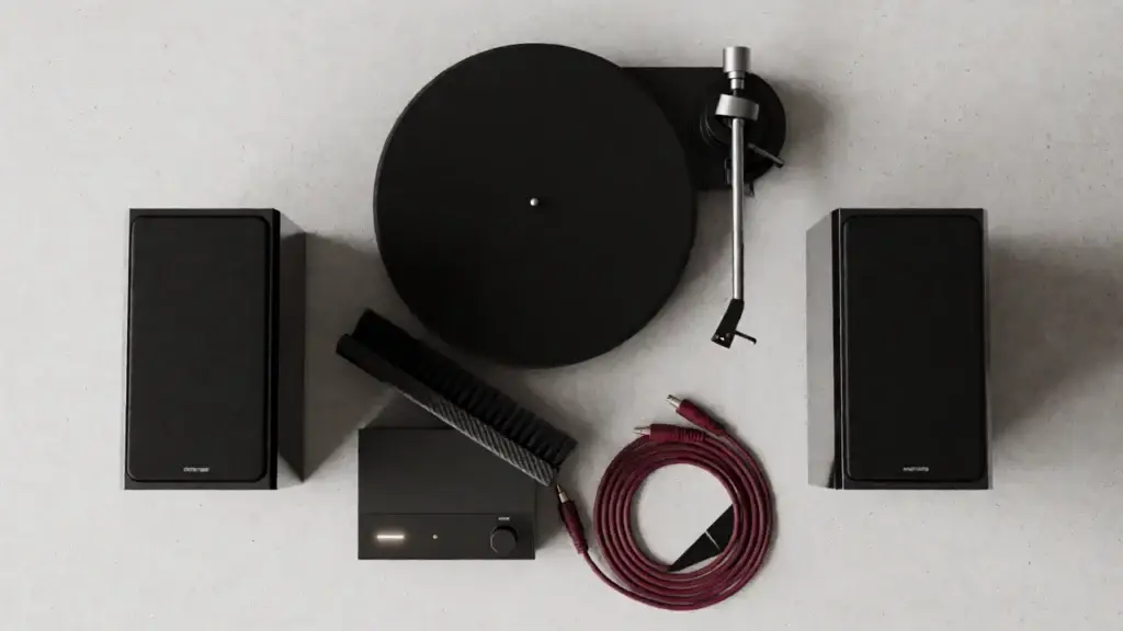Belt-drive beginner turntable with dust cover open on an oak sideboard beside bookshelf speakers &ndash; alternate angle